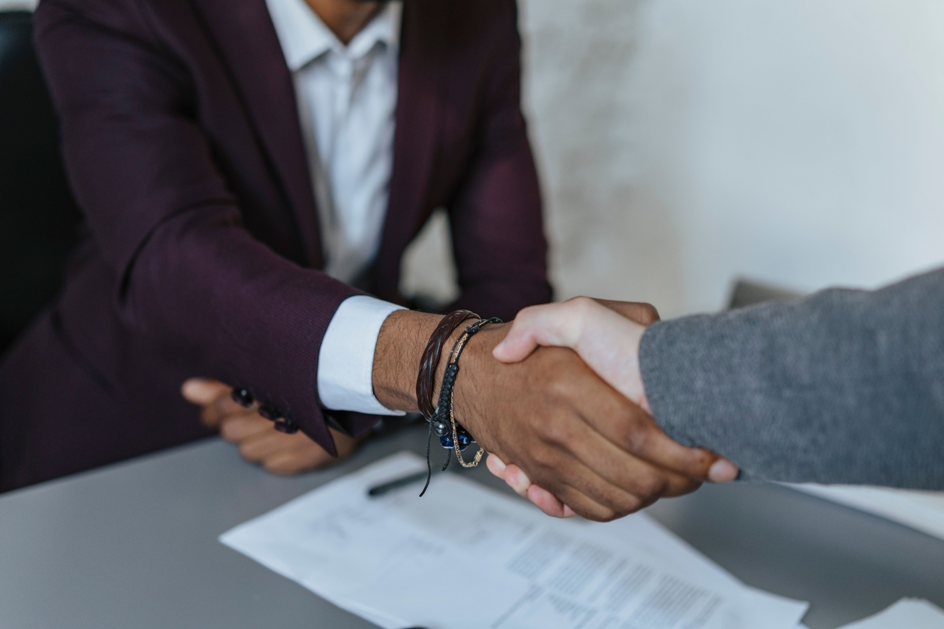 Two principals shaking hands across a desk